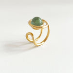 une chevalière eclipse en vermeil, vue de profil, trois quart. on voit la forme du corps de bague, sur le dessus la perle de verre de murano ronde entourée de la première boucle du huit. vue legerement de dessus